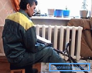 На фото сантехніком проводиться промивка радіаторів опалення в квартирі На фото сантехніком проводиться промивка радіаторів опалення в квартирі